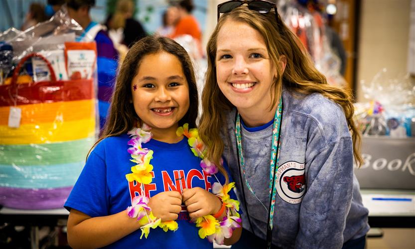 A student and teacher smile